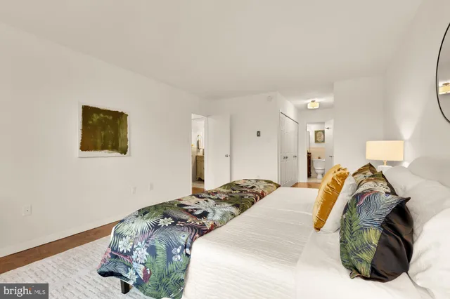 a bedroom with a bed and a lamp on dresser