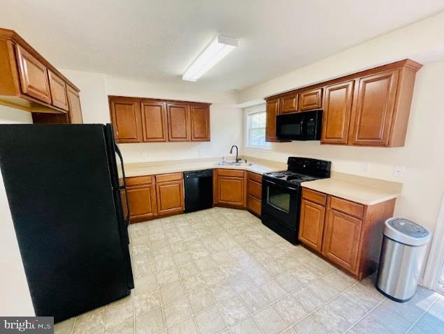 220 5th Street Colonial Beach, VA 22443 - Photo 4 of 25 a large kitchen with a stove top oven a sink dishwasher and a refrigerator with wooden cabinets