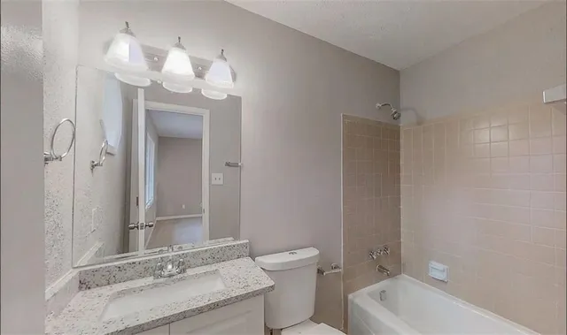 a bathroom with a granite countertop sink a mirror and a shower