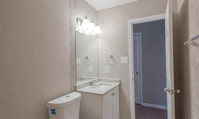 a bathroom with a granite countertop sink a toilet and bathtub
