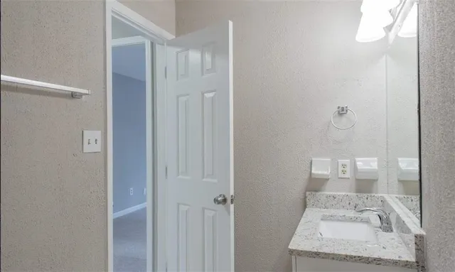 a bathroom with a sink vanity mirror and toilet