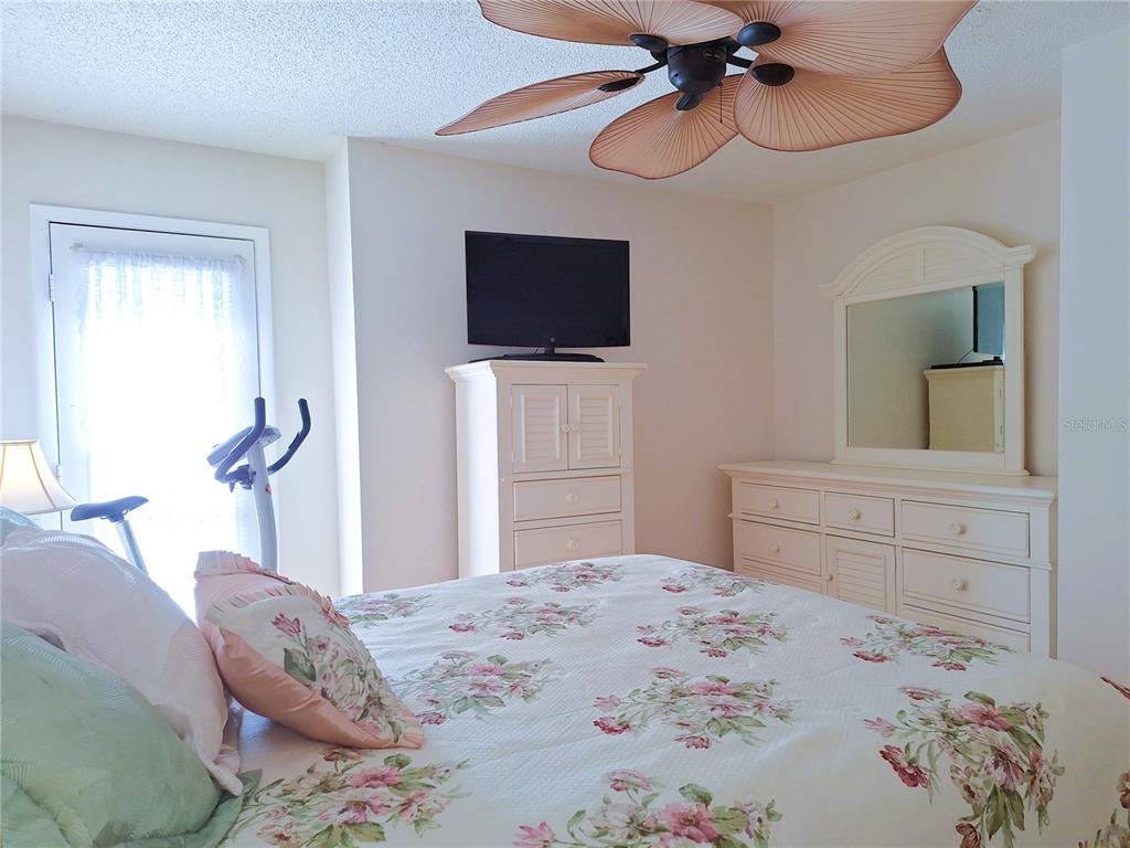 5727 Biscayne Court, Unit 302 New Port Richey, FL 34652 - Photo 16 of 45 a bedroom with a bed and a flat screen tv