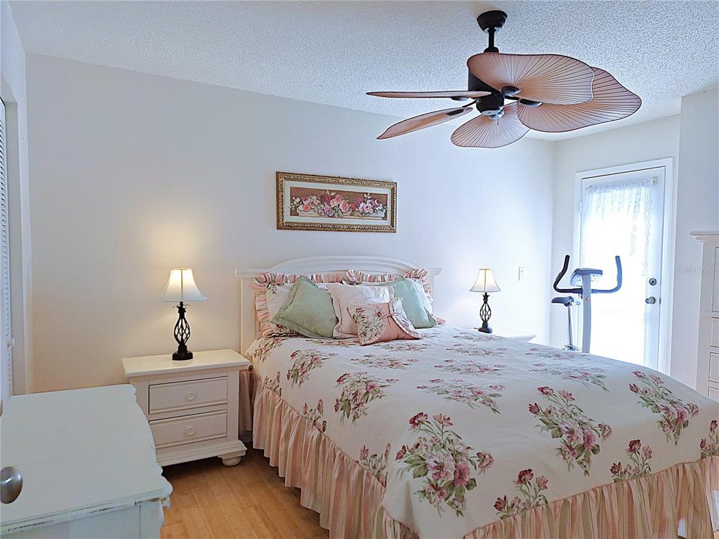 5727 Biscayne Court, Unit 302 New Port Richey, FL 34652 - Photo 17 of 45 a bedroom with a bed and a chandelier