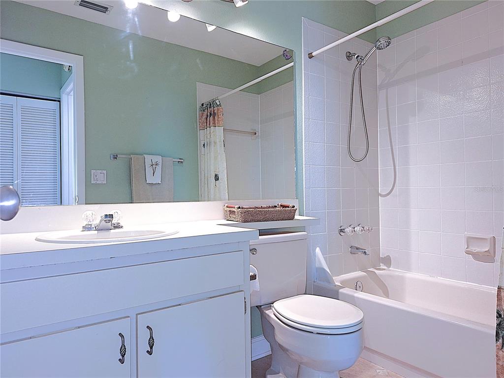 5727 Biscayne Court, Unit 302 New Port Richey, FL 34652 - Photo 18 of 45 a bathroom with a granite countertop sink toilet mirror and bathtub