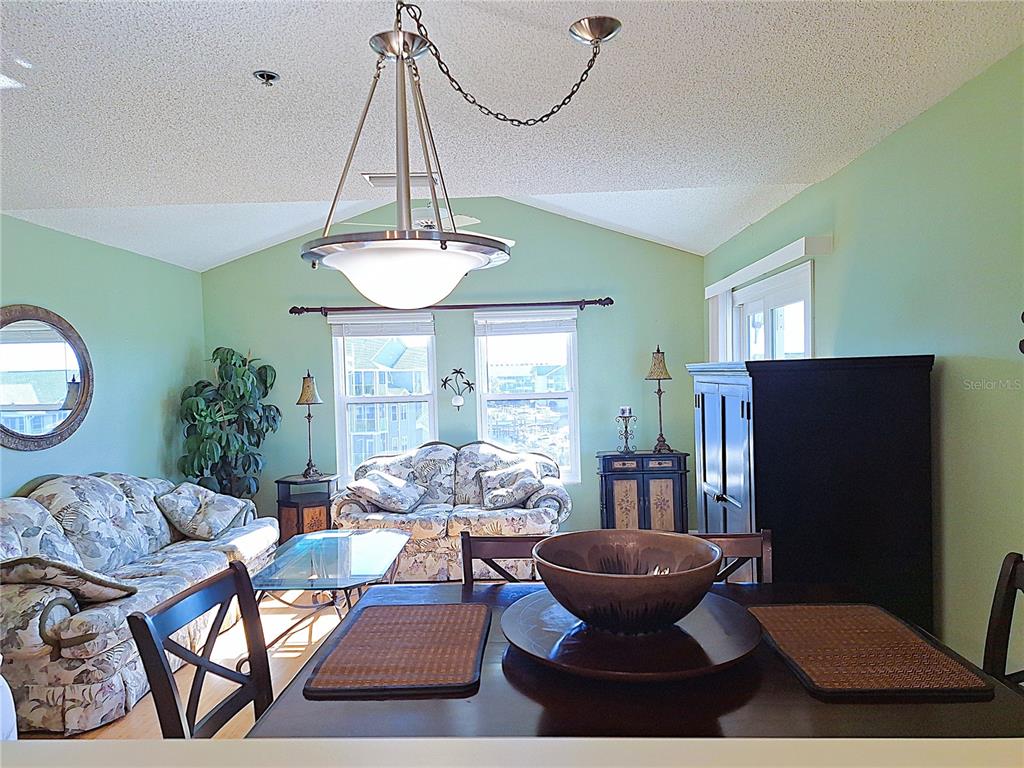 5727 Biscayne Court, Unit 302 New Port Richey, FL 34652 - Photo 7 of 45 a living room with furniture a window and a chandelier