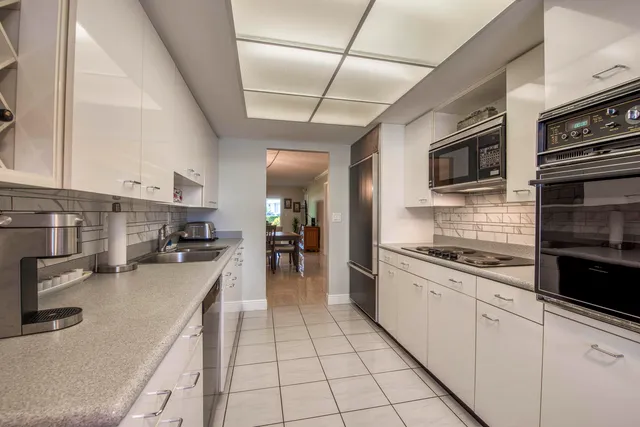 a large kitchen with stainless steel appliances granite countertop a stove sink and cabinets