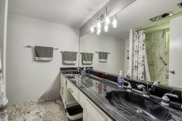 a kitchen with a sink a stove a microwave and a shower