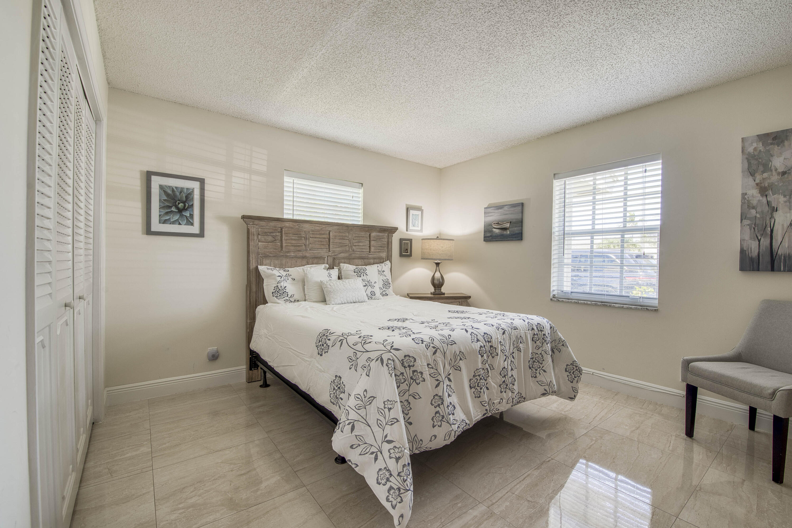 1205 Sandy Lane, Unit 149 Singer Island, FL 33404 - Photo 23 of 28 a bed sitting in a bedroom next to a window