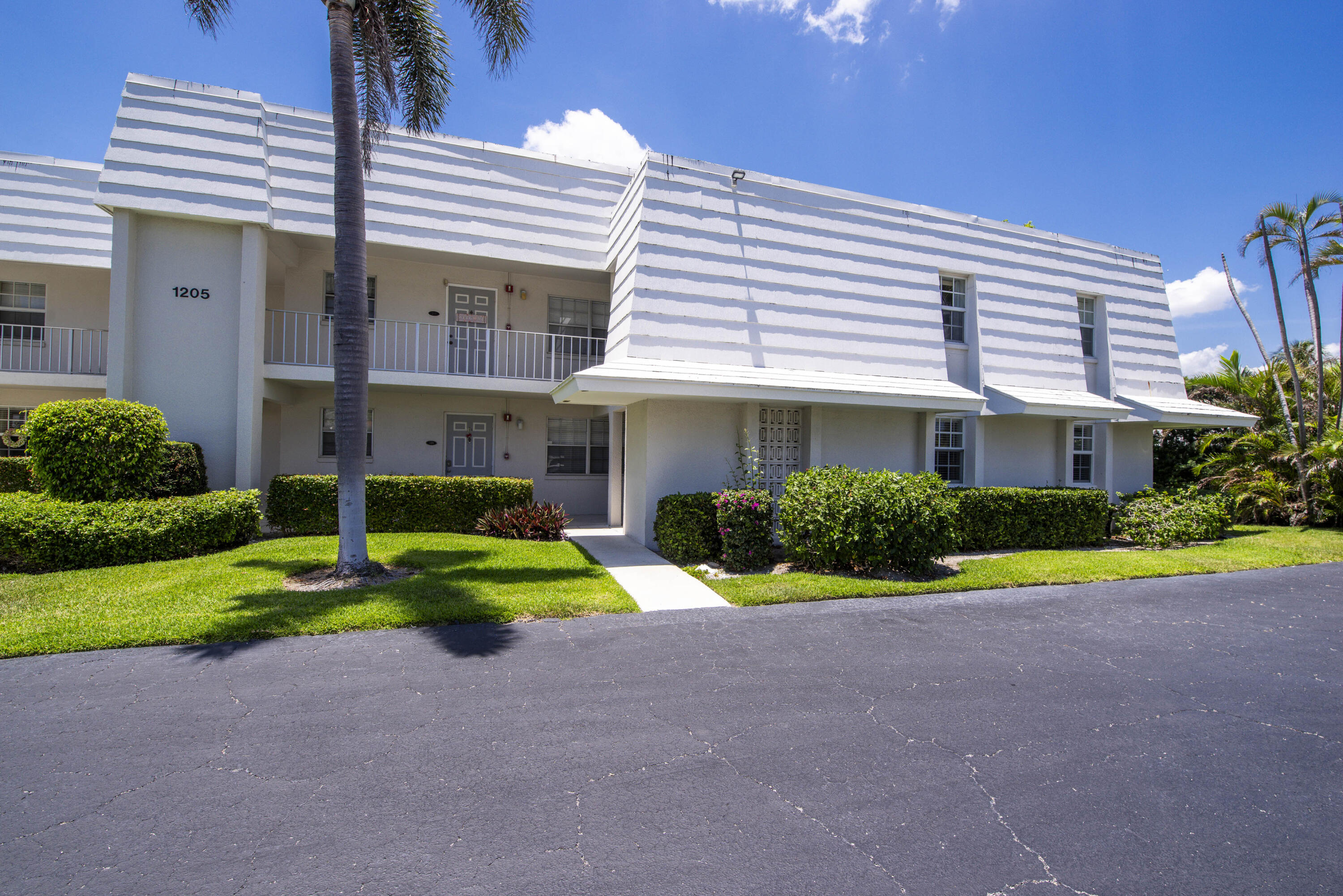 1205 Sandy Lane, Unit 149 Singer Island, FL 33404 - Photo 3 of 28 a front view of a house with a yard and garage
