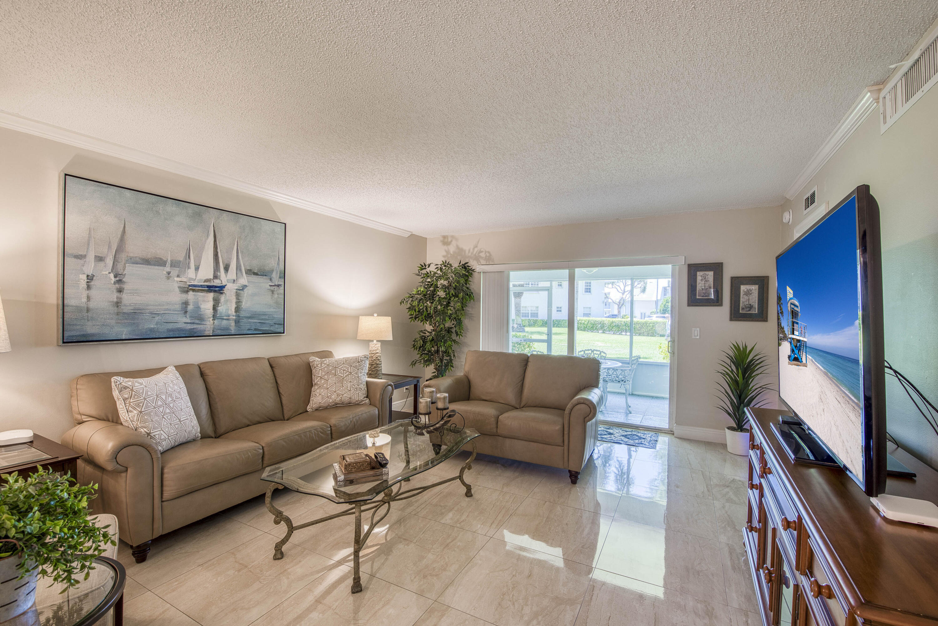 1205 Sandy Lane, Unit 149 Singer Island, FL 33404 - Photo 7 of 28 a living room with furniture flat screen tv and a large window