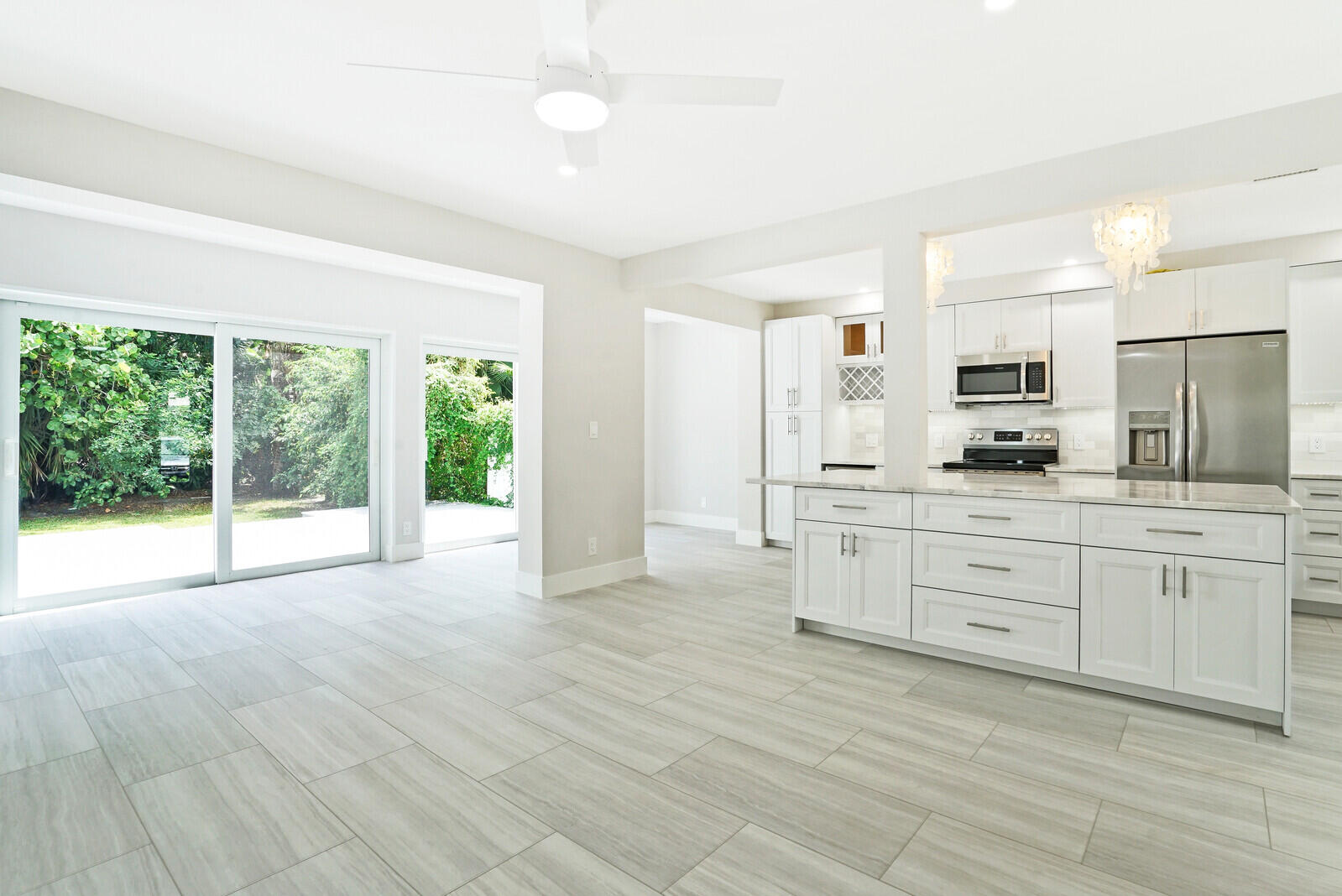 29 E Road Delray Beach, FL 33483 - Photo 11 of 34 a large kitchen with granite countertop a large window and white cabinets