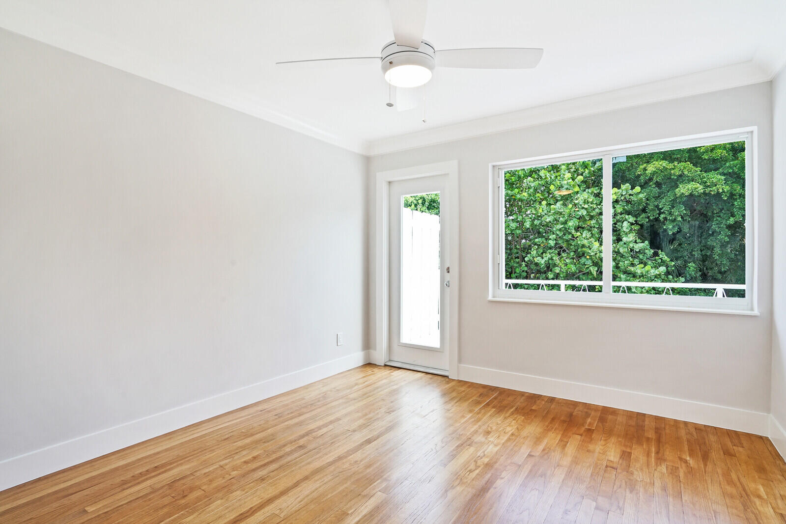 29 E Road Delray Beach, FL 33483 - Photo 18 of 34 an empty room with wooden floor and windows