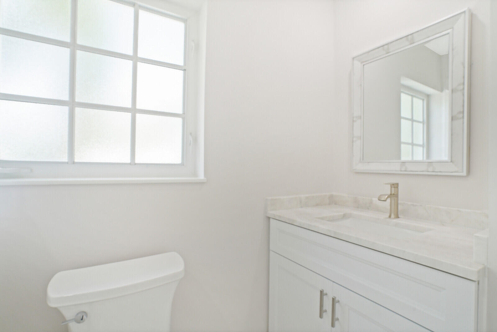 29 E Road Delray Beach, FL 33483 - Photo 23 of 34 a bathroom with a toilet sink vanity and mirror
