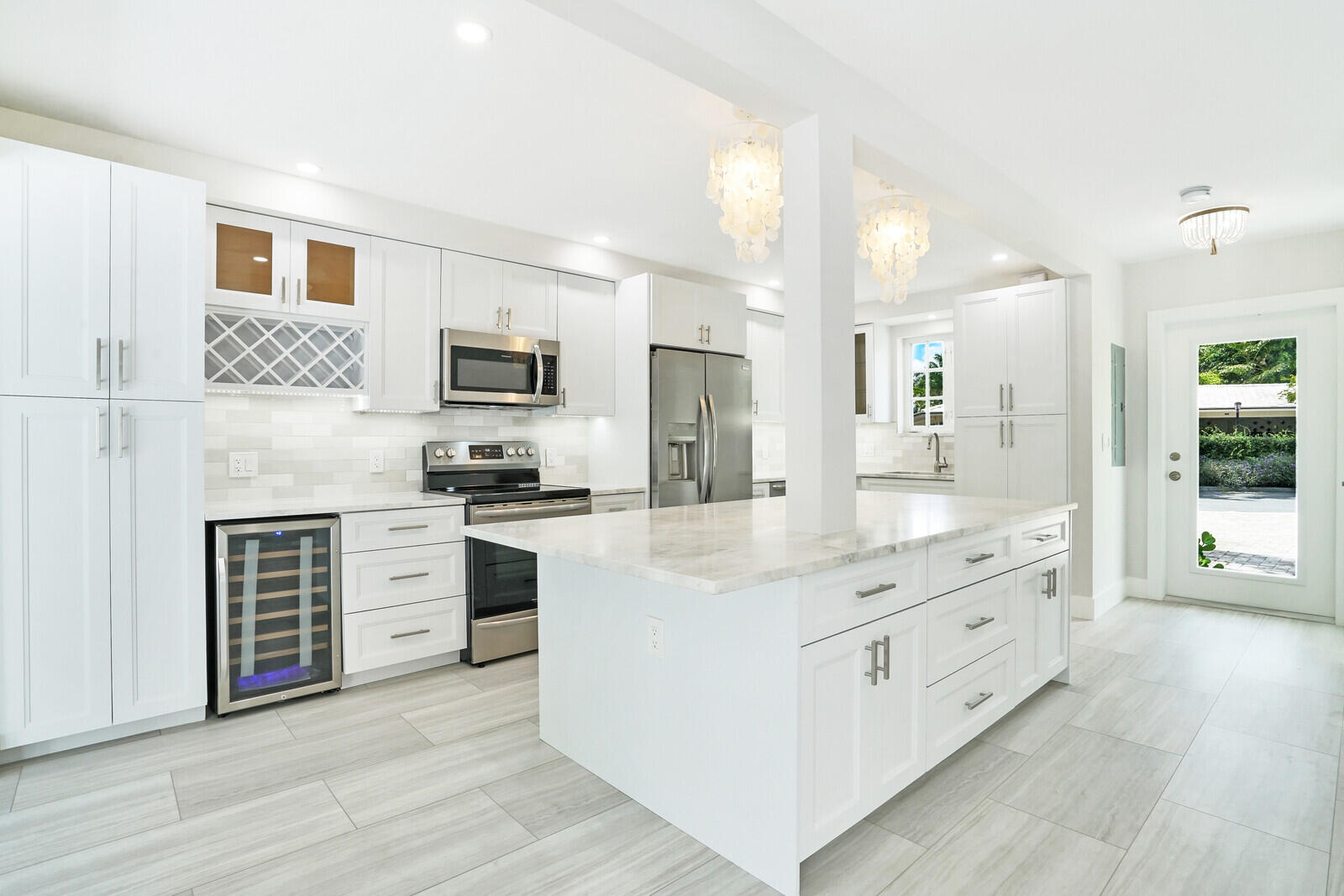 29 E Road Delray Beach, FL 33483 - Photo 8 of 34 a large kitchen with stainless steel appliances granite countertop a stove top oven a sink dishwasher and a refrigerator with wooden floor