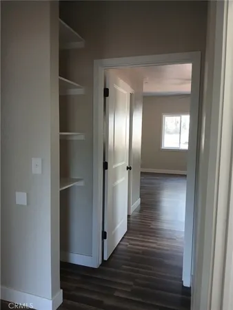 a view of a hallway with wooden floor and closet