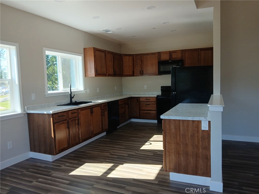 14014 Creston Road Magalia, CA 95954 - Photo 30 of 30 a kitchen with granite countertop a refrigerator a sink and wooden cabinets