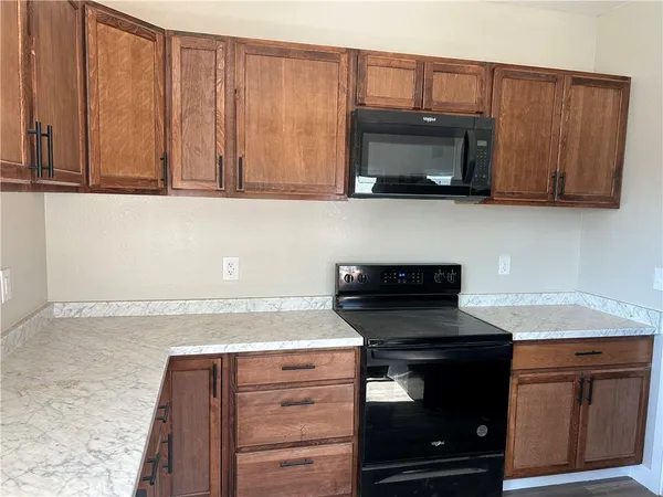 a kitchen with granite countertop wood cabinets and stainless steel appliances