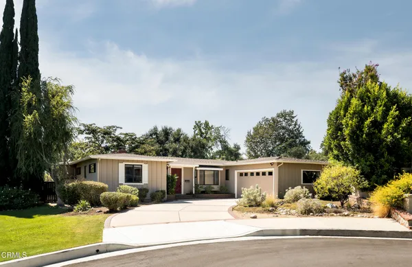 a front view of a house with yard and parking