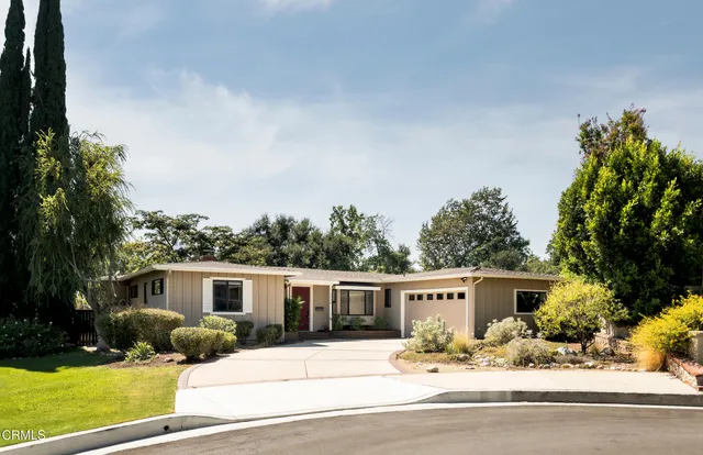 a front view of a house with yard and parking