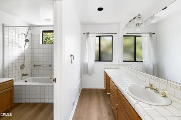 a bathroom with a tub sink and mirror