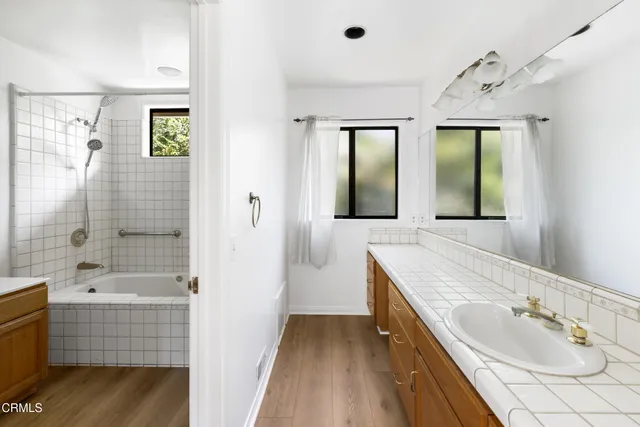 a bathroom with a tub sink and mirror
