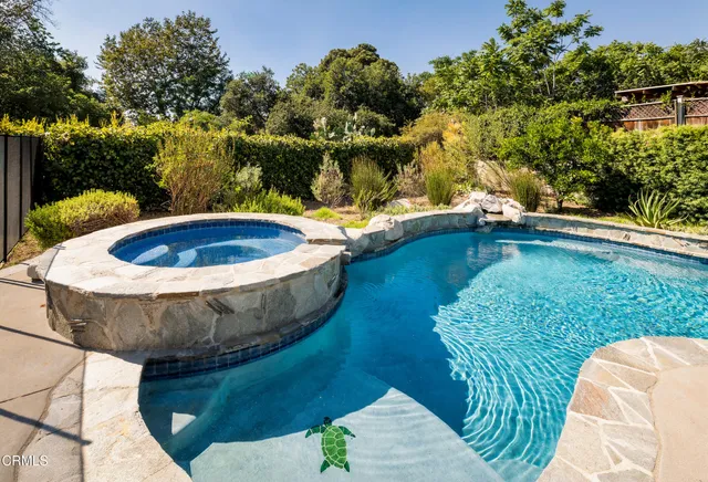 a view of a swimming pool with a yard and sitting area