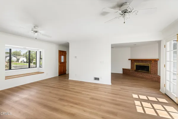 an empty room with windows and fireplace