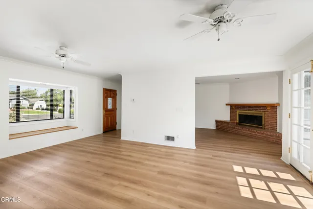 an empty room with windows and fireplace