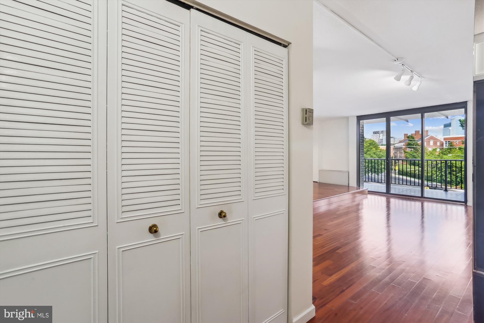 4242 East-West Highway, Unit 414 Chevy Chase, MD 20815 - Photo 11 of 66 a view of a room with wooden floor and windows