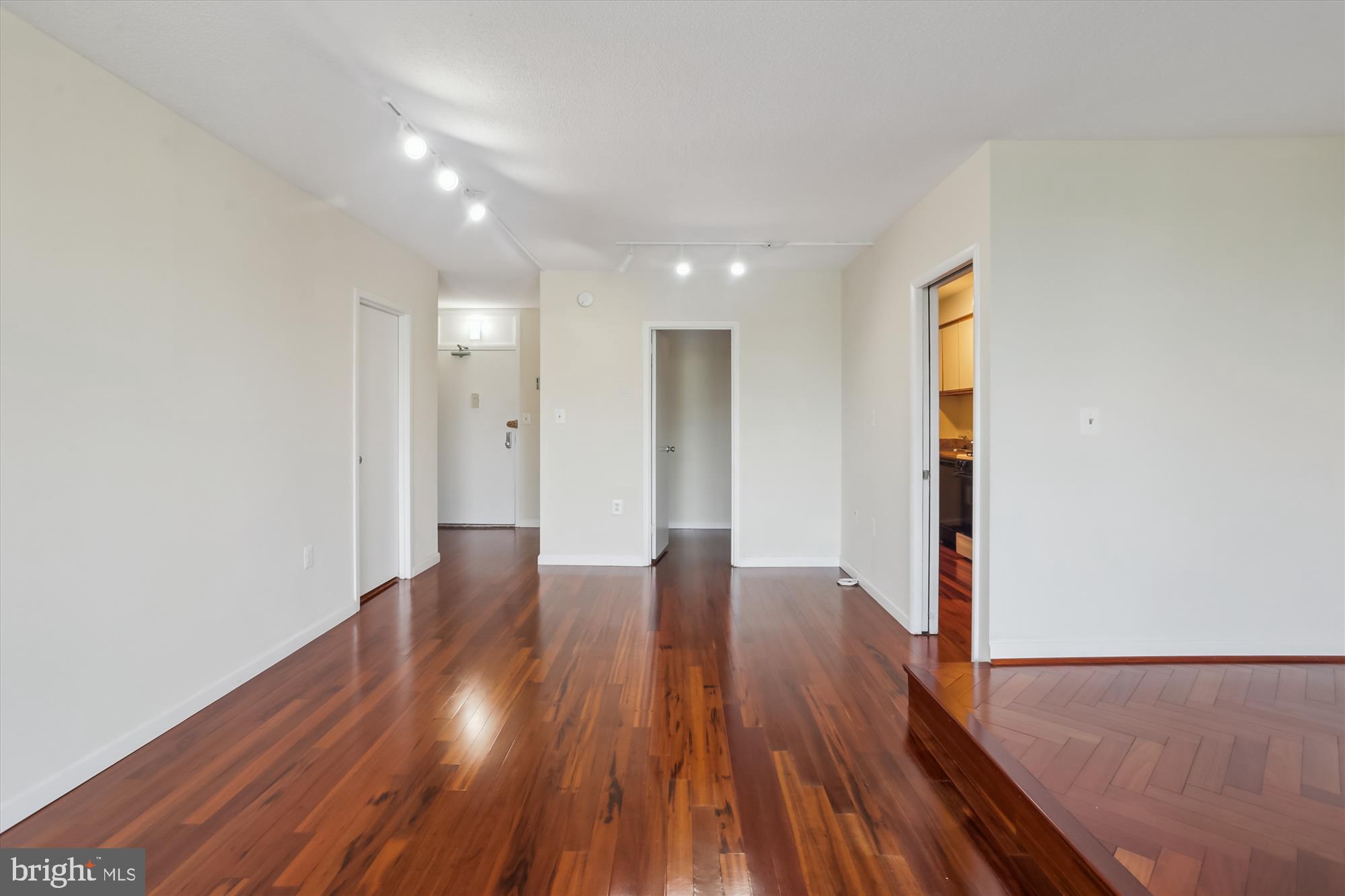 4242 East-West Highway, Unit 414 Chevy Chase, MD 20815 - Photo 13 of 66 a view of an empty room with wooden floor