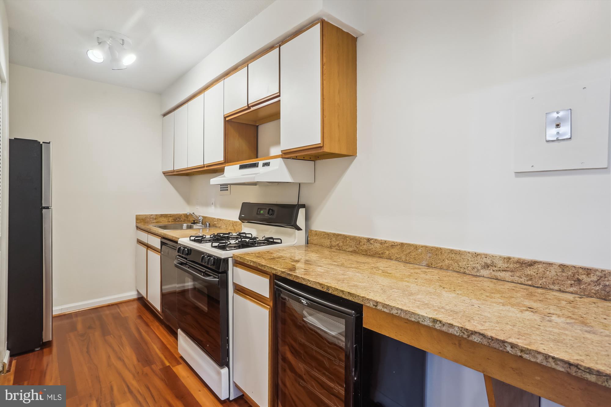 4242 East-West Highway, Unit 414 Chevy Chase, MD 20815 - Photo 18 of 66 a kitchen with a stove and a microwave