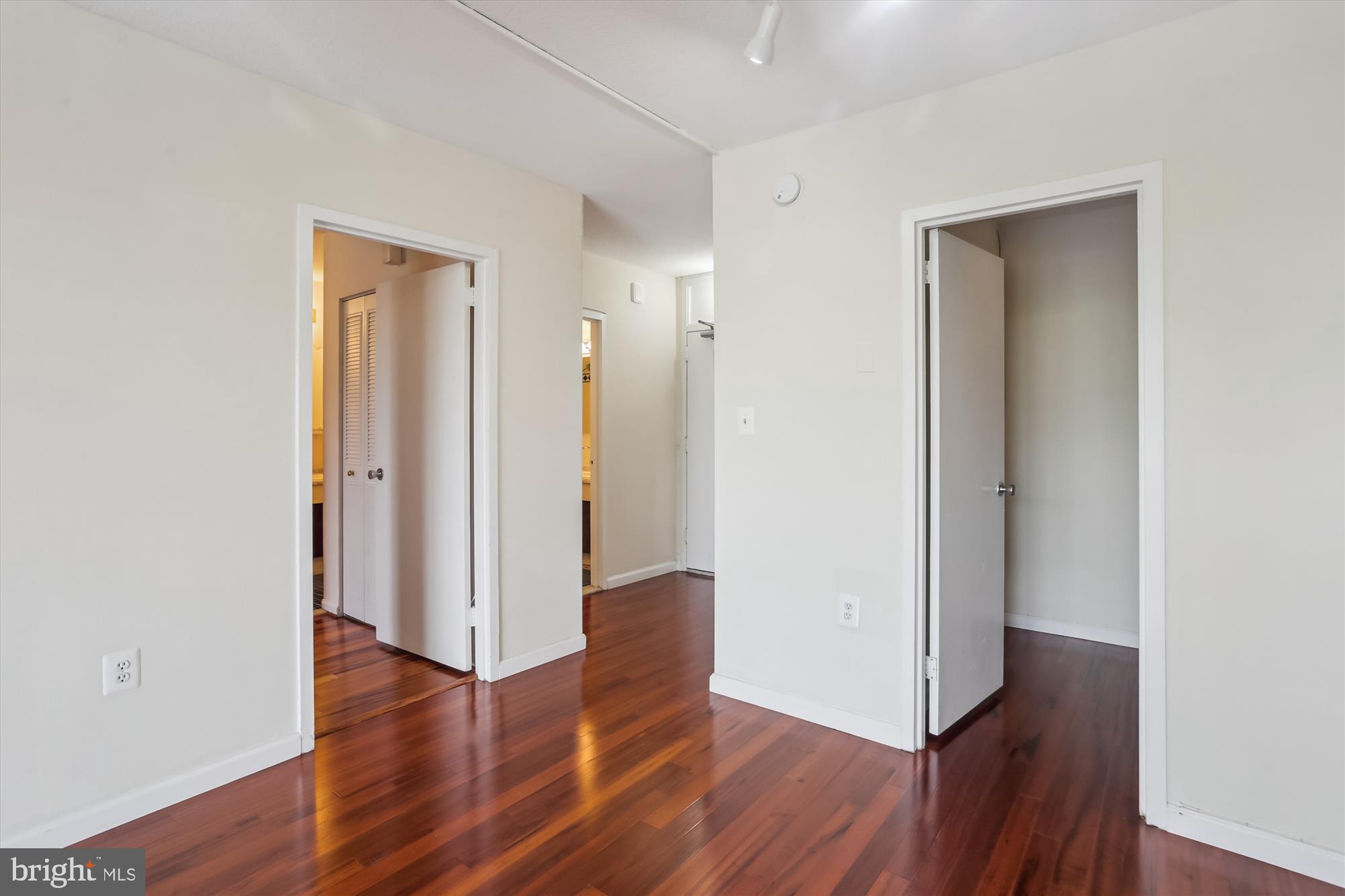 4242 East-West Highway, Unit 414 Chevy Chase, MD 20815 - Photo 21 of 66 an empty room with wooden floor and closet