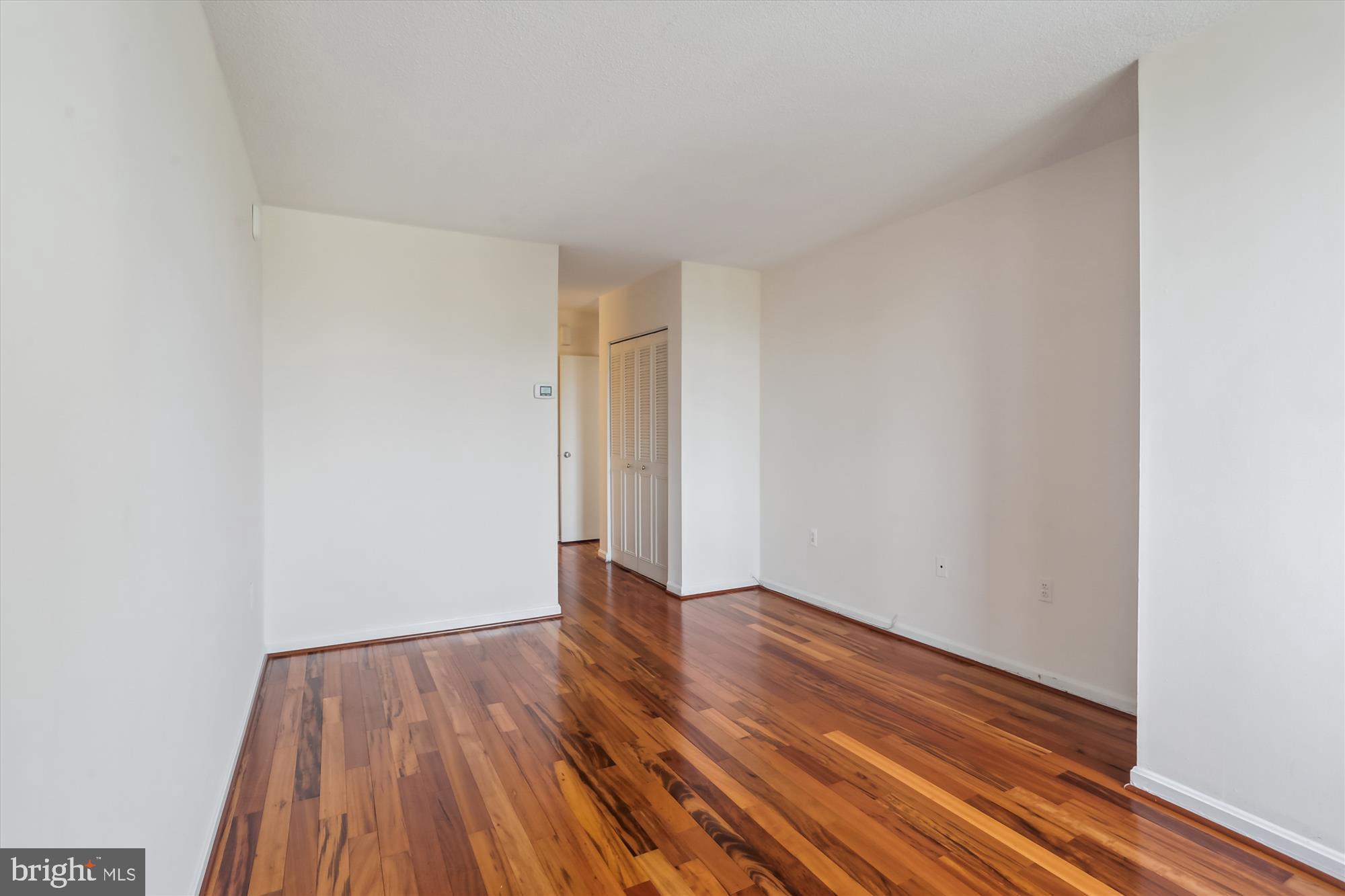 4242 East-West Highway, Unit 414 Chevy Chase, MD 20815 - Photo 23 of 66 a view of an empty room with wooden floor