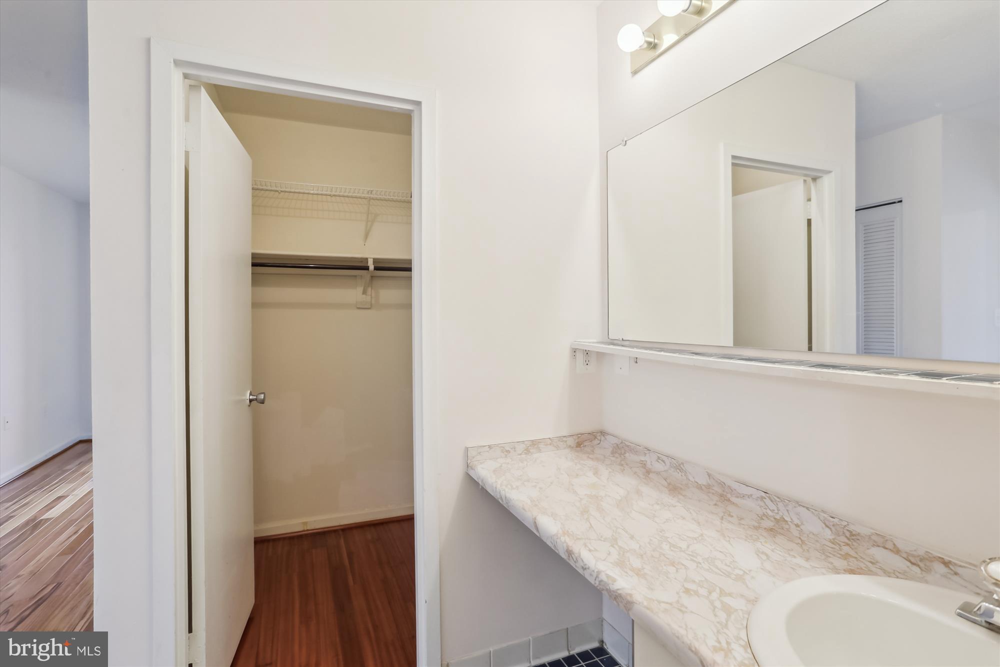 4242 East-West Highway, Unit 414 Chevy Chase, MD 20815 - Photo 26 of 66 a bathroom with a granite countertop sink and vanity