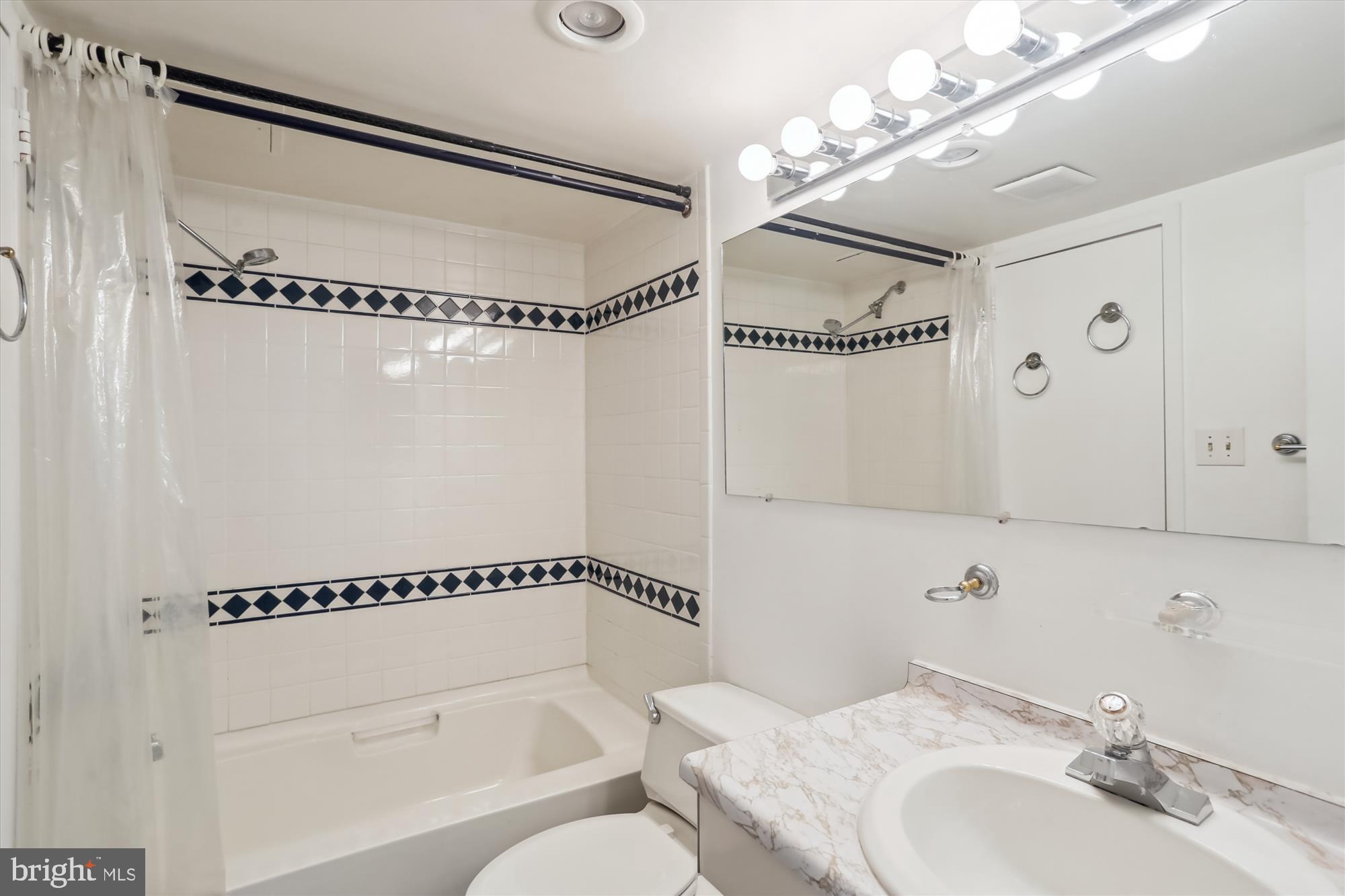 4242 East-West Highway, Unit 414 Chevy Chase, MD 20815 - Photo 28 of 66 a bathroom with a granite countertop sink mirror vanity and a shower