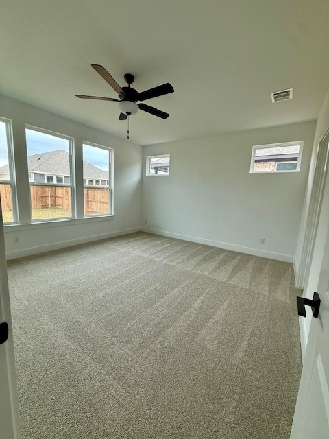 121 Prodigal Way Kyle, TX 78640 - Photo 8 of 12 en empty room with windows and ceiling fan view