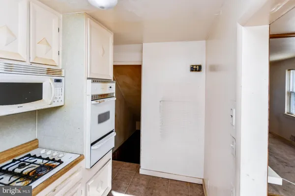 a kitchen with stainless steel appliances a refrigerator a stove and white cabinets