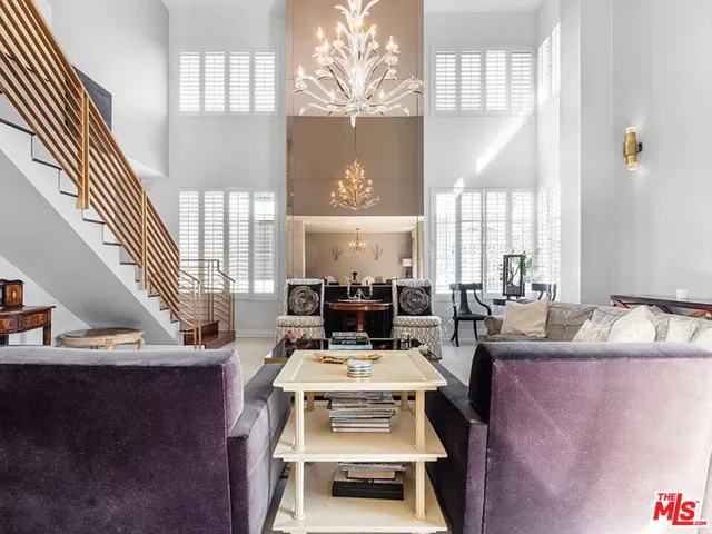 a view of a dining room with furniture a chandelier and a large window
