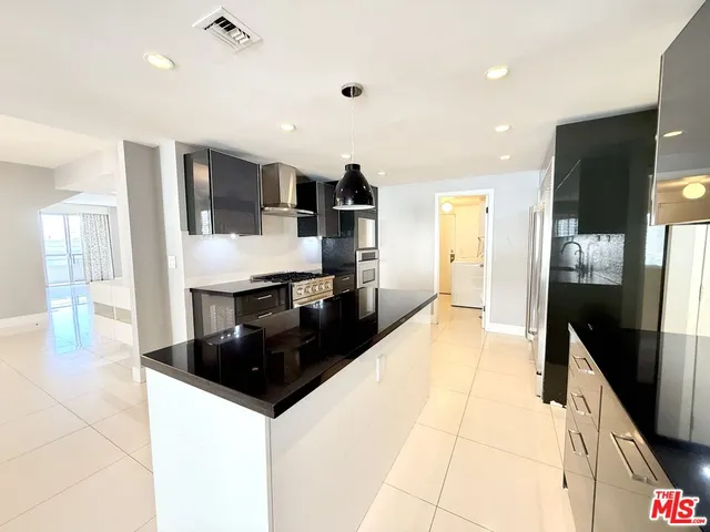 a kitchen with stainless steel appliances granite countertop a stove and a refrigerator