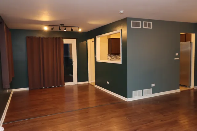 a view of an empty room with wooden floor