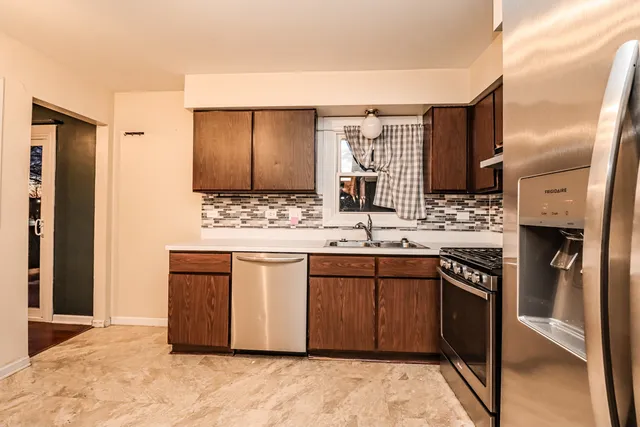 a kitchen with kitchen island a sink stainless steel appliances and cabinets