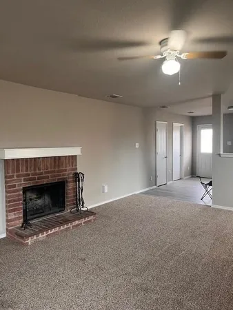 a living room with a fireplace and a ceiling fan