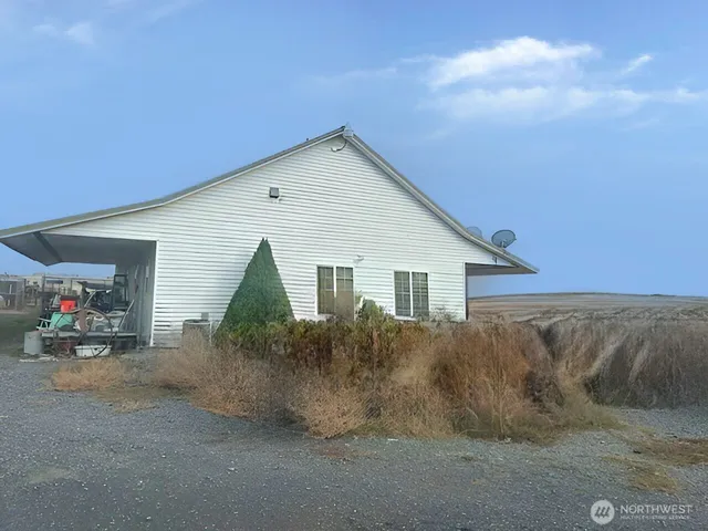 a view of a house with a small yard and potted plants