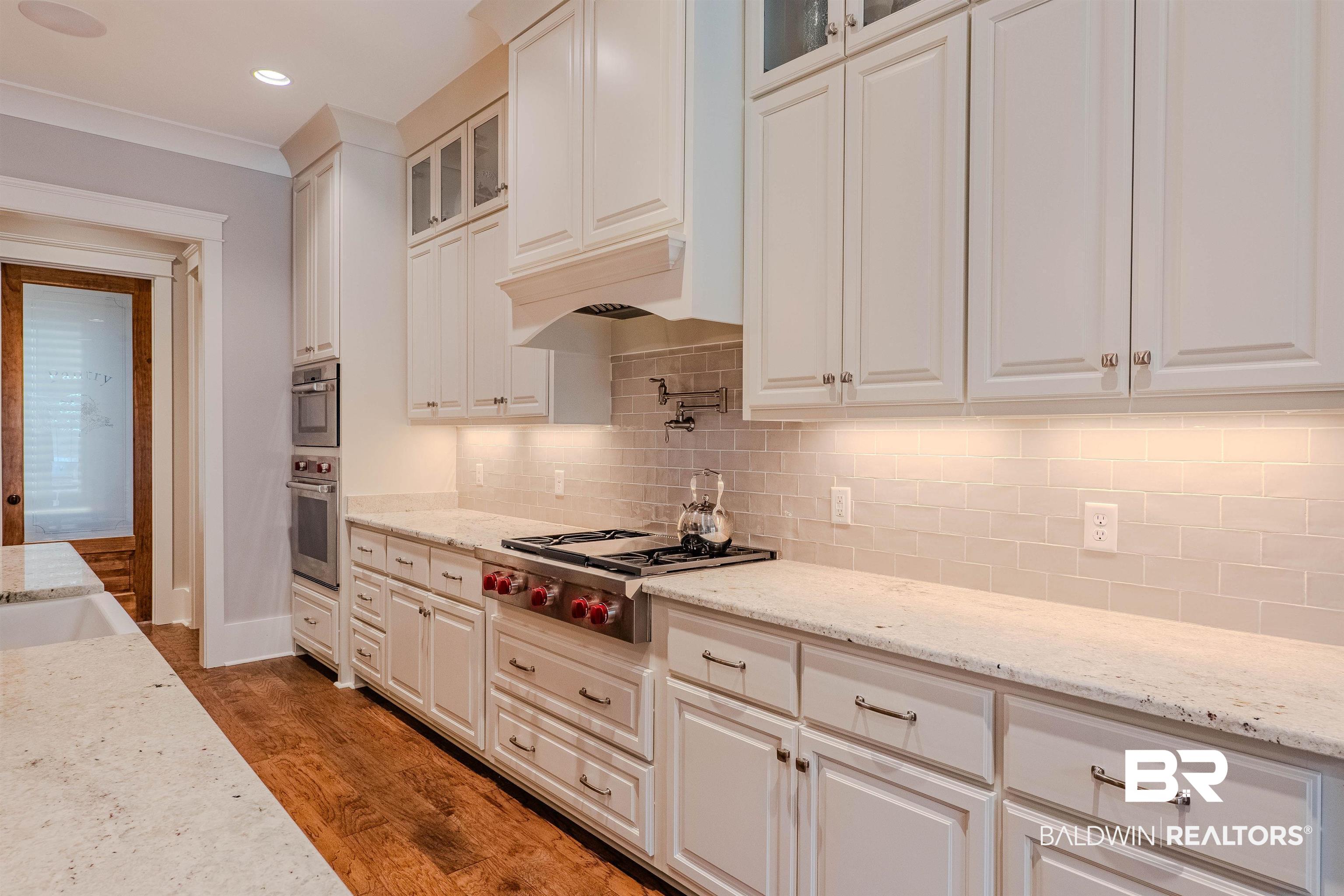 708 Manning Place Fairhope, AL 36532 - Photo 10 of 58 Kitchen featuring stainless steel gas cooktop, white cabinets, and light stone counters