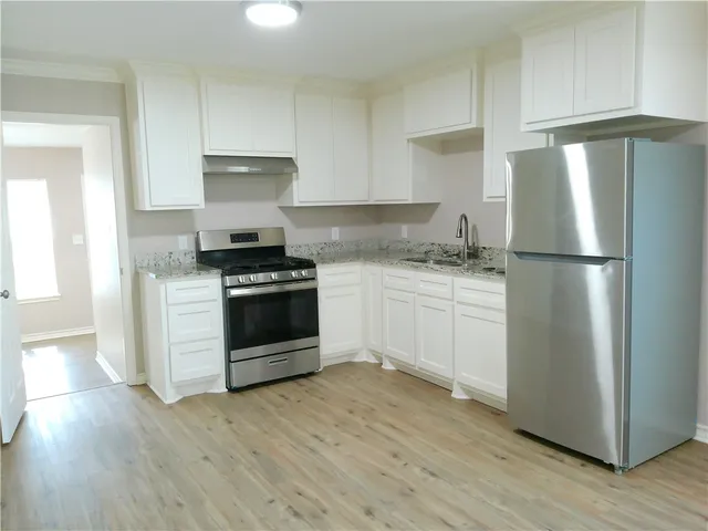 a kitchen with a stove a refrigerator and a sink