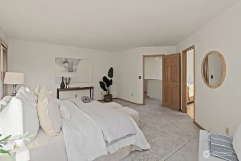 a spacious bedroom with a bed and a mirror