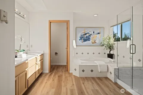 a spacious bathroom with a double vanity sink a mirror and a bathtub