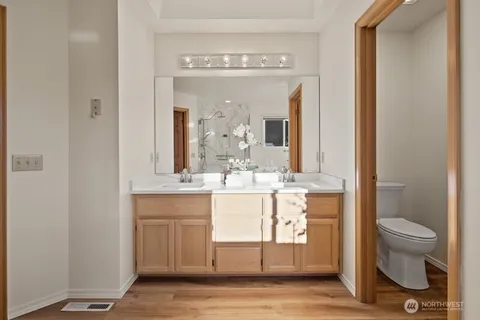 a bathroom with a granite countertop sink a toilet and a mirror