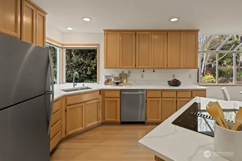 a kitchen with a refrigerator sink and cabinets
