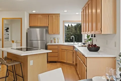a kitchen with a sink refrigerator and window